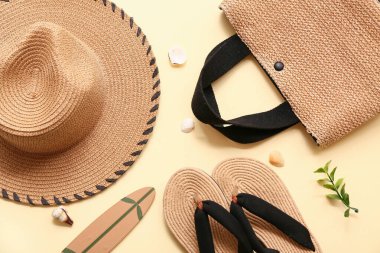 Kadın plaj aksesuarları ve arka planda mini sörf tahtası olan kompozisyon