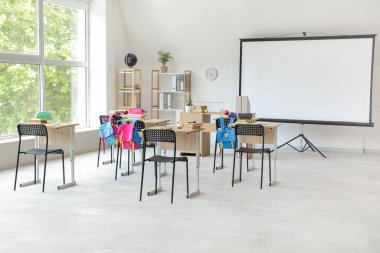 Projektör ekranlı ve masalı ışık sınıfının içi