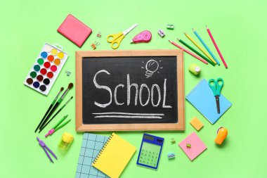 Metin Okunmuş yazı tahtası ve yeşil arkaplanda farklı kırtasiye malzemesi