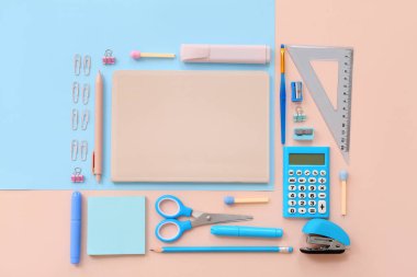 Bej arka planda not defteri, makas ve hesap makinesi olan okul malzemeleri. Üst görünüm