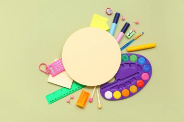 Okul malzemeleri, palet, cetvel ve yeşil arka planda boş kart. Üst görünüm