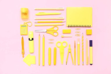 Okul malzemeleri pembe arka planda, defter, makas ve bölme ile. Üst görünüm