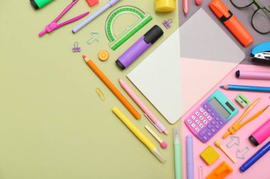 Not defteri, hesap makinesi ve renkli arkaplan işaretleri olan okul malzemeleri. Üst görünüm