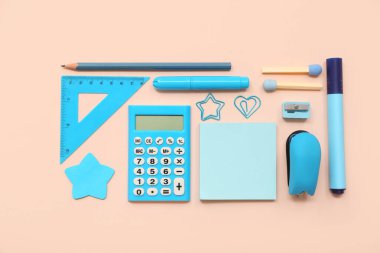 Pembe arka planda hesap makinesi ve farklı kırtasiye malzemesi