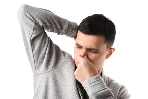 stock image Handsome young man feeling bad smell from armpits on white background