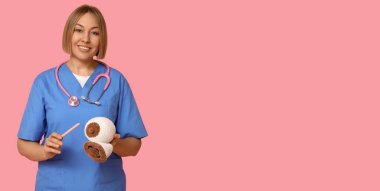 Pembe arka planda, kadın göğsü ve insan ağzı modeli örülmüş, yazı için yeri olan bir doktor. Emzirme kavramı