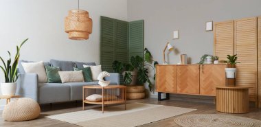 Gri kanepeli, katlanır perdeli ve masalı modern oturma odasının içi.