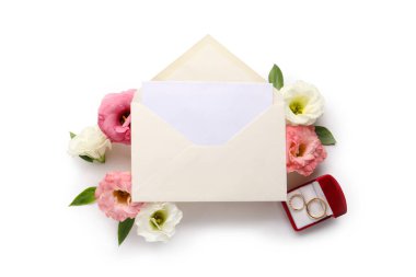 Zarflı kompozisyon, boş kart, alyans ve beyaz arkaplanda östoma çiçekleri