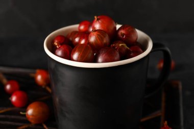 Siyah arka planda taze bektaşi üzümlü bir fincan.