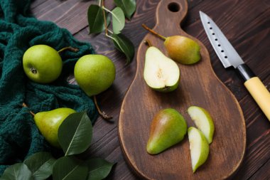 Dilimlenmiş armut ve bıçaklı tahta masa.