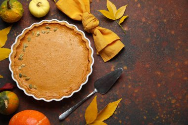 Kahverengi arka planda lezzetli balkabağı turtasıyla sonbahar kompozisyonu