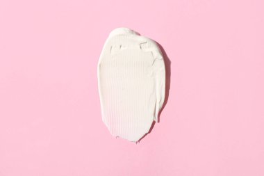 Pembe arka planda kozmetik kremi örneği