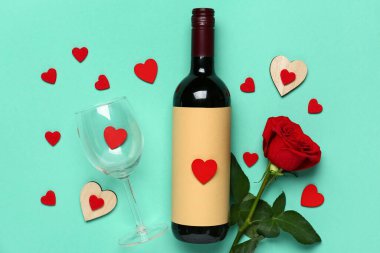 Turkuaz arka planda Sevgililer Günü için şarap, gül çiçeği ve cam karışımı.