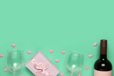 Turkuaz arka planda Sevgililer Günü için şarap, hediye kutusu ve gözlüklü kompozisyon