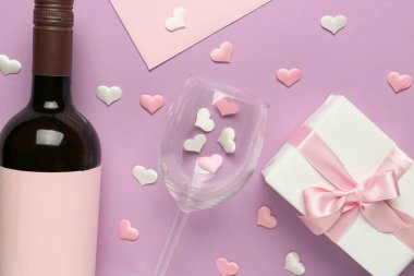 Leylak arkaplanda Sevgililer Günü için şarap, cam ve hediye kutusuyla kompozisyon