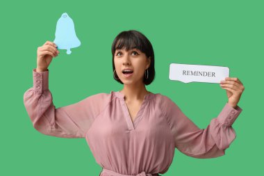 Yeşil arka planda metin REMINDER ve çan simgesi ile konuşma balonu tutan güzel genç kadın