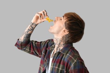 Genç dövmeli adam arka planda patates cipsi yiyor, yakın plan.