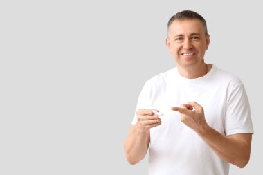 Kontak lensi ve gri arkaplanı olan olgun bir adam