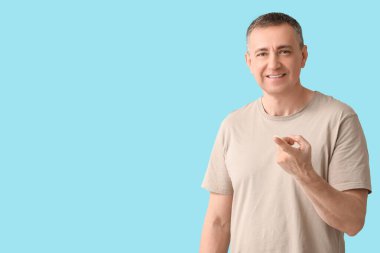 Mavi arka planda kontak lensli olgun bir adam