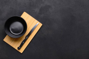 Siyah arka planda kesme tahtası ve kase