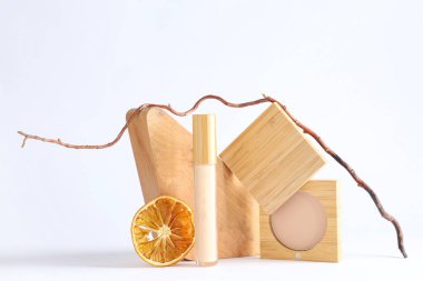 Pudra, kapatıcı, ahşap dekor, beyaz arka planda kurutulmuş portakal ve ağaç dalı.