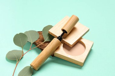 Maskara, toz, ağaç kabuğu ve dalları yeşil arka planda, yakın plan