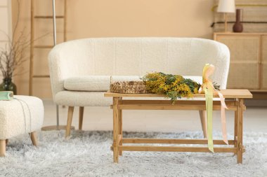 Oturma odasındaki masada güzel mimoza çiçekleri