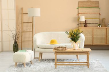 Oturma odasındaki masada güzel mimoza çiçekleri olan vazo.