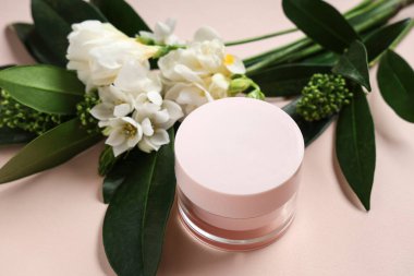 Renkli arkaplanda doğal krema kavanozu ve güzel çiçekleri olan kompozisyon