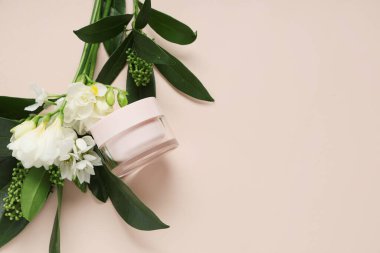 Renkli arkaplanda doğal krema kavanozu ve güzel çiçekleri olan kompozisyon