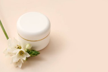 Renkli arkaplanda krema ve frezya çiçeği var.