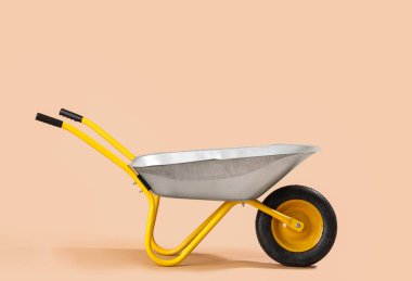 Bej arkaplanda boş el arabası