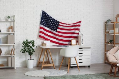 Rahat çalışma alanının üzerinde Amerikan bayrağı asılı modern oturma odasının içi