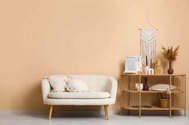 Rahat bir kanepe ve oturma odasının içinde şık dekorları olan ahşap bir raf.