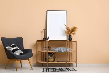 Rahat siyah koltuk ve raflar vazoda otlu vazo, boş çerçeve ve modern oturma odasının içinde heykel.