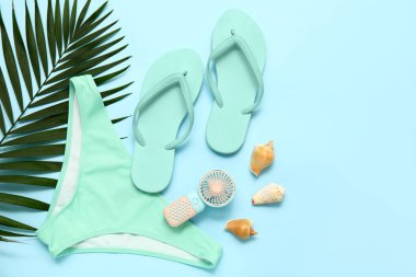 Mayo, tropikal yaprak, deniz kabuğu ve mavi arka planda taşınabilir elektrikli vantilatör.