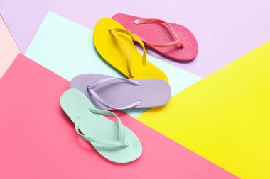 Renk arkaplanında farklı parmak arası terlikler