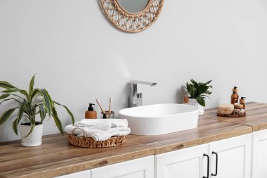 Modern lavabo, banyo malzemeleri ve banyo odunları banyodaki ışıklı duvarın yanındaki çekmecelerde.