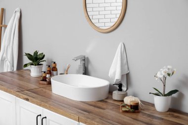Modern lavabo, banyo malzemeleri çekmecelerde ve banyodaki ışık duvarında ayna.