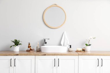 Modern lavabo, banyo malzemeleri çekmecelerde ve banyodaki ışık duvarında ayna.