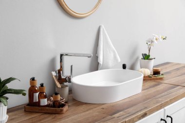 Kozmetik ürünleri şişeleri ve banyodaki ahşap masaya lavabo.