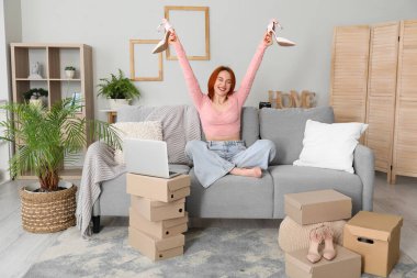 Evde yeni ayakkabıları olan genç bir kadın.