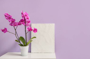 Leylak duvarının yanındaki klozette boyanmış orkide çiçeği.