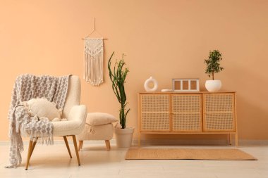 Şık oturma odasının içinde dekoratif ve rahat koltuklu ahşap dolap.