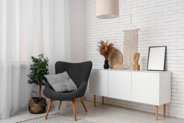 Şık oturma odasının içinde dekoratif ve rahat koltuklu beyaz dolap.