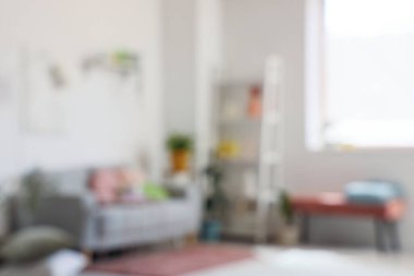 Rahat kanepesi ve kahve masası olan, bulanık manzaralı bir oturma odası.