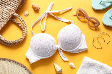 Turuncu arka planda mayo ve plaj aksesuarları.