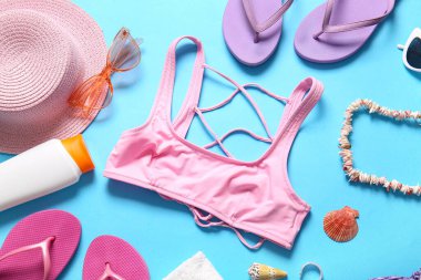 Mavi arka planda mayolu ve plaj aksesuarlı güzel bir kompozisyon.