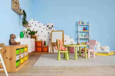 Oyun odasında sandalyeli raf ve masa