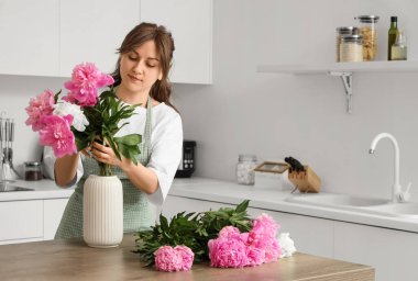 Mutfakta şakayıklarla çalışan kadın çiçekçi.